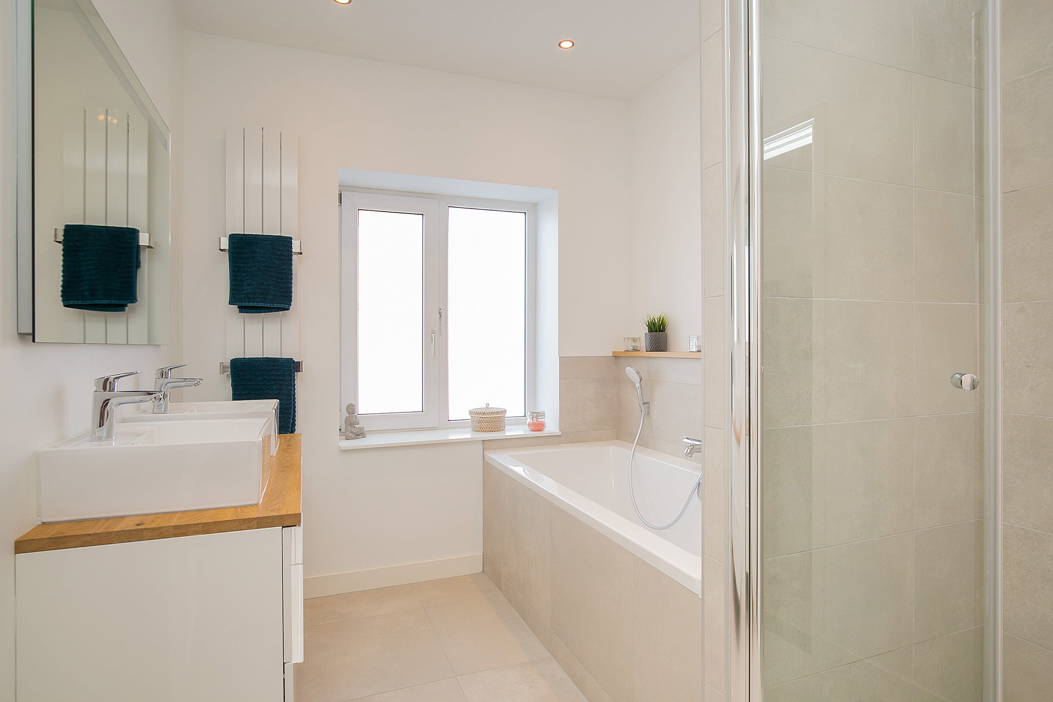 Moderne lichte badkamer met douche, ligbad en dubbele wastafel. Renovatie appartement in Voorburg.